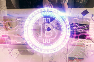 Double exposure of man and woman working together and crypto finance theme hologram. Blockchain business concept. Computer background.