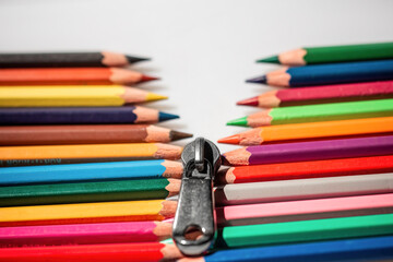 Fototapeta premium Two rows of multi-colored pencils imitating a zipper that diverge
