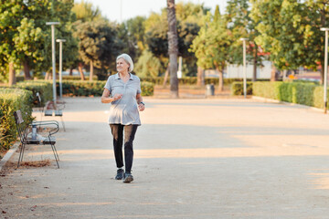 Fototapeta premium Older woman playing sports in an outdoor park