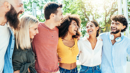 Multiracial group of friends having fun together at the park - Happy international students smiling walking in college campus - Happy lifestyle concept with guys and girls enjoying day out