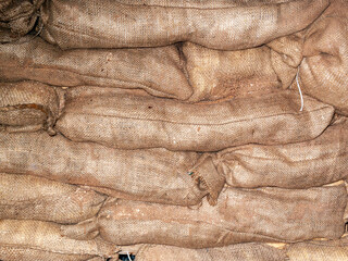 Sandbags background stacked in a heap for use as flood defence or for the military as a barricade, stock photo image