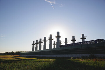 View from a field to the power generators of a large nuclear power plant with blue sky in the...