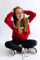 Beautiful little girl model wearing hoodie sitting on white studio background