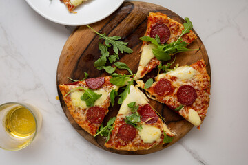 Sliced italian salami pizza on wooden board top view