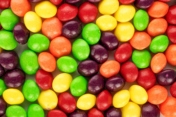 A lot of sweet colored candies, close-up, top view.