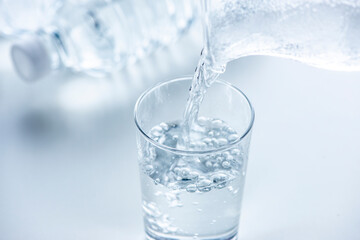 テーブルに置いたコップとペットボトル
