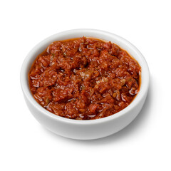 Ceramic bowl with tomato tapenade close up isolated on white background