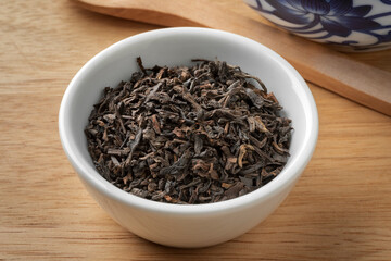 Bowl with Chinese Pu Ehr dried tea leaves close up 