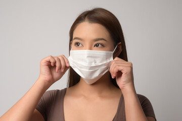 Young asian woman wearing protective mask over white background studio, safety travel , new normal , social distancing , covid19 and pandemic concept.
