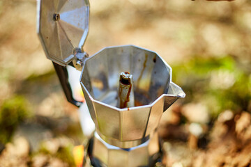 Making camping coffee from a geyser coffee maker on a gas burner