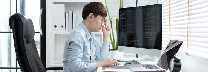 Professional development programmers are sit on a desk with work equipment such as: computer-laptop-tablet. for working in programming or writing code on  website,  HTML, javascript, Software.