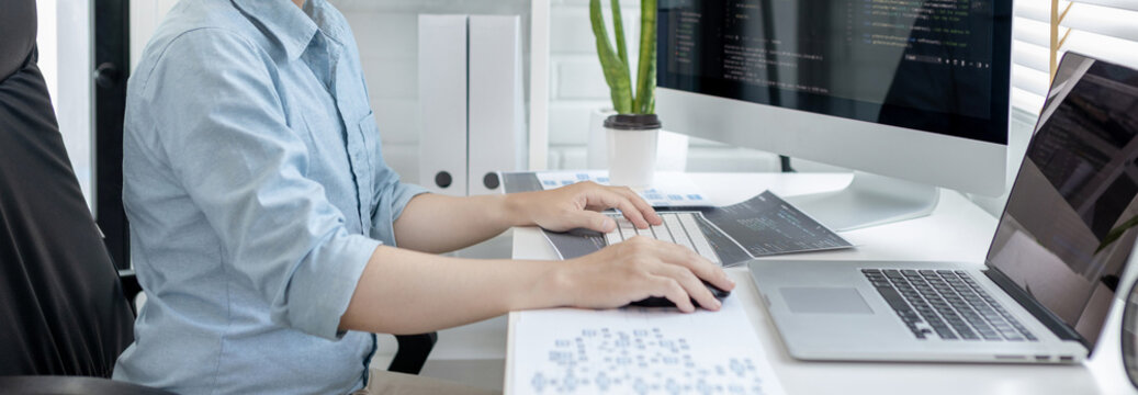 Professional development programmers are sit on a desk with work equipment such as: computer-laptop-tablet. for working in programming or writing code on  website,  HTML, javascript, Software.