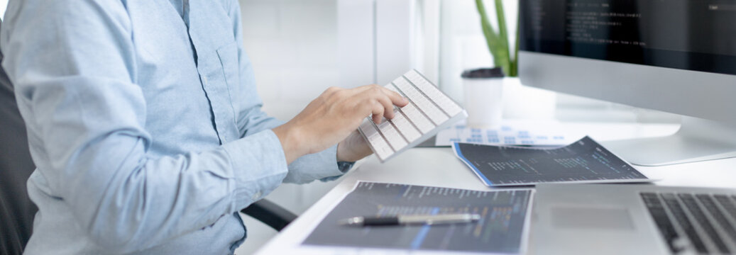 Professional development programmers are sit on a desk with work equipment such as: computer-laptop-tablet. for working in programming or writing code on  website,  HTML, javascript, Software.
