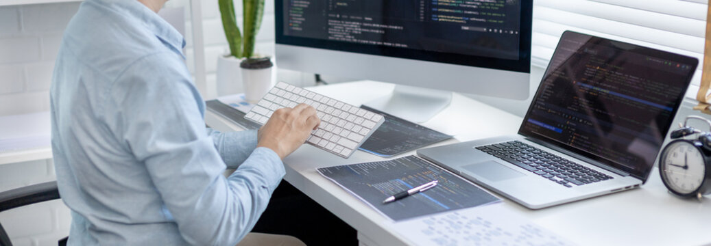 Professional development programmers are sit on a desk with work equipment such as: computer-laptop-tablet. for working in programming or writing code on  website,  HTML, javascript, Software.