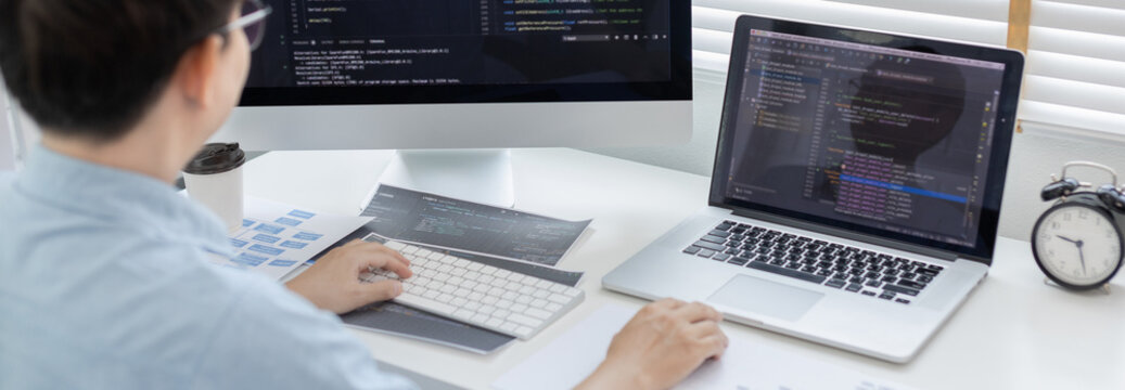 Professional development programmers are sit on a desk with work equipment such as: computer-laptop-tablet. for working in programming or writing code on  website,  HTML, javascript, Software.