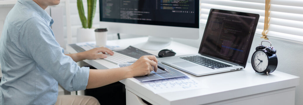 Professional development programmers are laying out a structure or draft on paper in preparation for coding on a computer, Write information or code for the website,  HTML, javascript, Software.