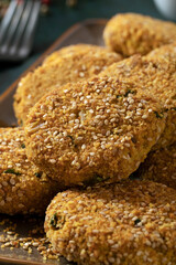 Nuggets (croquettes) with gluten free bread crumb and sesame seeds on a dark background. 