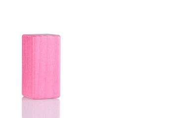 Wooden cube of pink color on a white background