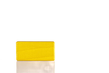 Wooden cube of yellow color on a white background
