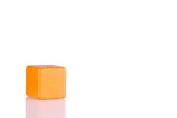 Wooden cube of orange color on a white background