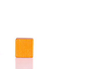 Wooden cube of orange color on a white background