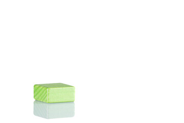 Wooden cube of green color on a white background