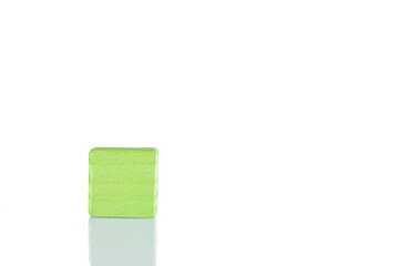 Wooden cube of green color on a white background