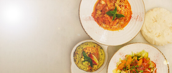 Dishes of Italian and Lebanese cuisine. farfalle pasta with kebab, hummus with avocado and seafood salad. Design for restaurant menu. Creative copy space.