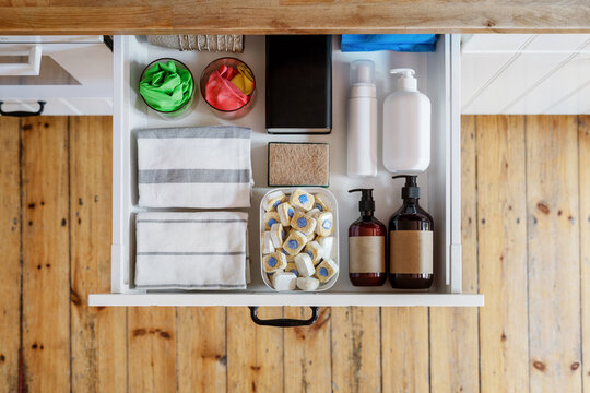 wooden drawer with dishwashing tablets and soap bottles at kitchen