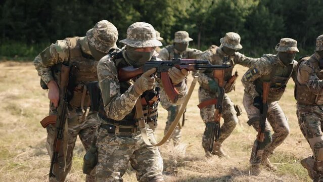 Soldiers with weapons and ammunition attack the enemy on the battlefield. This is a Military Special Forces Unit.