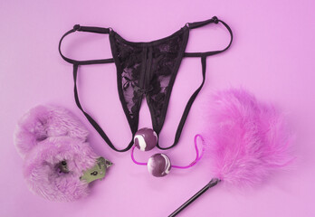 Different adult sex toys with black underwear. Vaginal balls, handcuffs, erotic feathers, black...