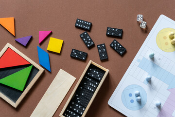 Different desktop games, figures, dices, parts on the brown table. Home entertaiment, indoor games