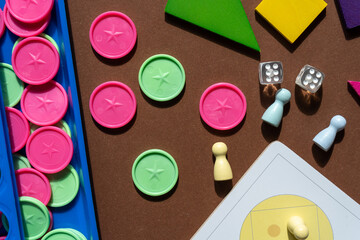 Different desktop games, figures, dices, parts on the brown table. Home entertaiment, indoor games