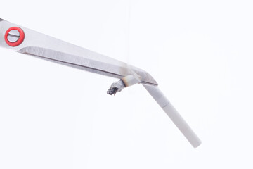 Scissors cut a burning cigarette on a white background. Concept of give up smoking, no tobacco day...