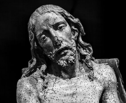 Black and white photo showing in close-up the suffering face of Jesus sculpted in stone