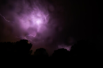 night sky with thunderstorm, lightning and thunder in purple colors