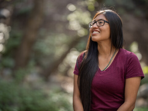 Portrait of a young Indigenous woman smiling while looking to her right 