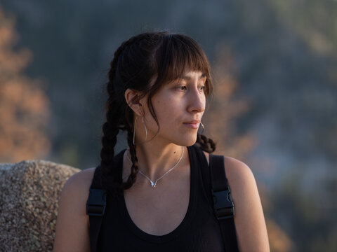 Young Indigenous woman in hiking gear looking to her left 