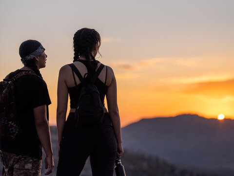 Indigenous friends looking out towards a mountain
