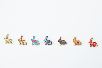 Wooden figures in the form of rabbits on a white background. Easter concept