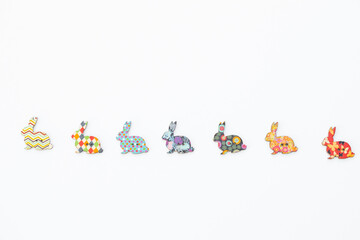 Wooden figures in the form of rabbits on a white background. Easter concept