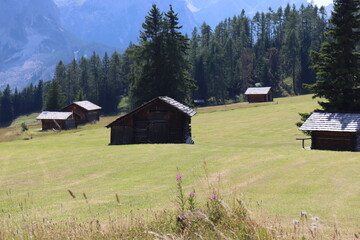 Obraz premium Val Badia, Italy-July 17, 2022: The italian Dolomites behind the small village of Corvara in summer days with beaitiful blue sky in the background. Green nature in the middle of the rocks.