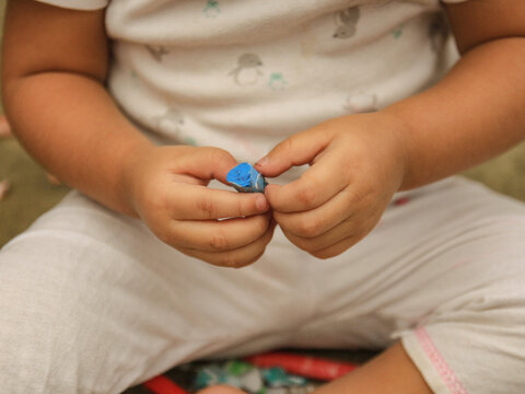 ni&ntilde;a con cray&oacute;n azul en las manos
