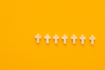 Christian cross on yellow background, top view with space for text. Religion concept