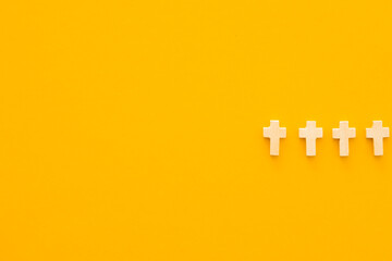 Christian cross on yellow background, top view with space for text. Religion concept
