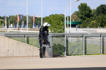Policjant oddziału prewencji na zabezpieczeniu imprezy sportowej. Tarcza policyjna.  - obrazy, fototapety, plakaty
