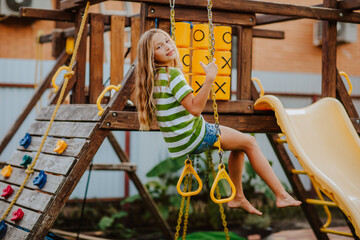 Girl is spending time at playground zone on back yard