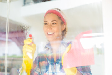 Young smiling woman cleaning the house 