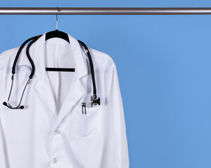 Medical white jacket hanging on blue wall
