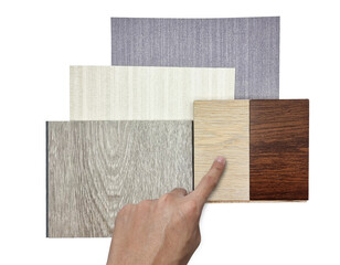 interior architect choosing finishing material samples including vinyl flooring, ash and italian walnut engineered flooring,  fabric interior wallpaper isolated on white background with clipping path.
